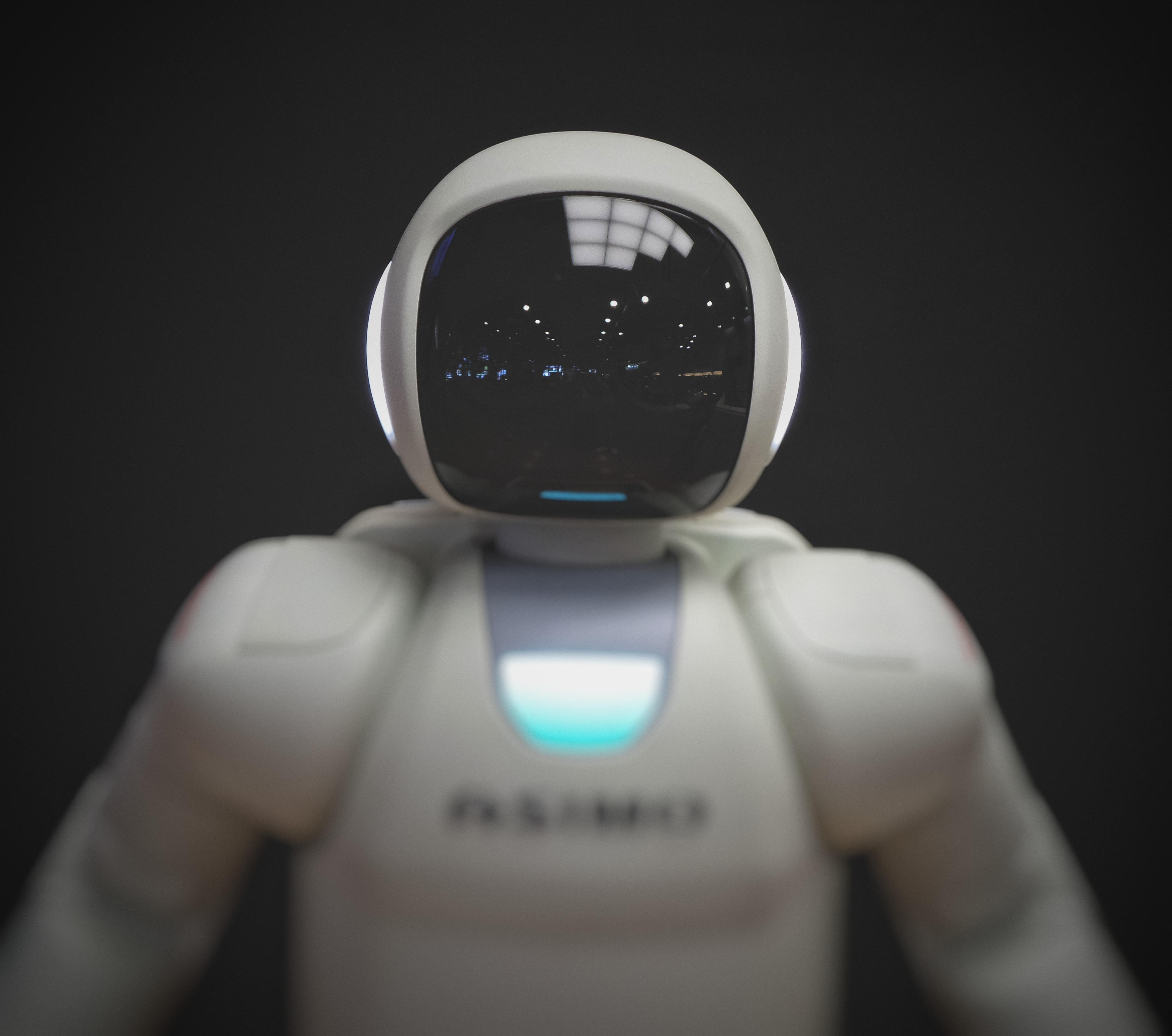 photo of a white plastic robot with
                a black background